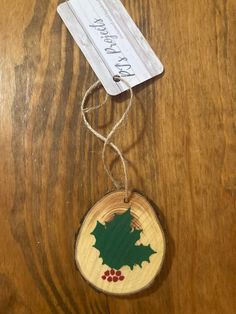 a wooden ornament with holly on it