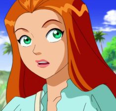 a woman with long red hair and green eyes looking at something in the distance while wearing a blue shirt