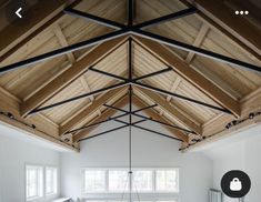 a living room filled with white furniture and wooden beams on top of the ceiling,