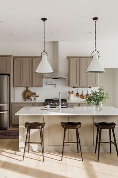 a kitchen with two stools next to an island