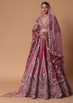 a woman in a pink lehenga and veil