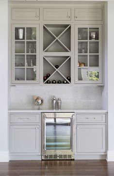 a kitchen with white cabinets and silver appliances