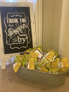 a bucket filled with yellow candy next to a chalkboard that says thank you for popcorn by