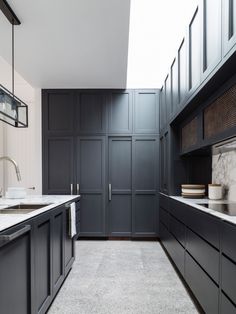 a kitchen with black cabinets and white counter tops