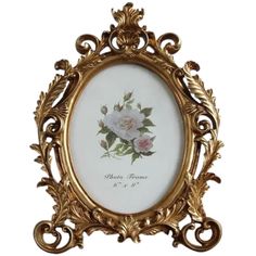 an ornate gold frame with a white rose in the center and green leaves on it