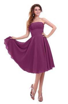 a woman in a purple dress posing with her hands on her hips and wearing high heels