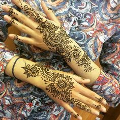 two hands with henna tattoos on them