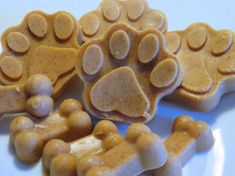 three dog paw shaped treats on a white plate