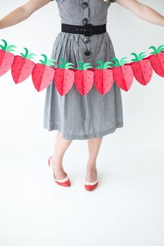 an image of a woman wearing strawberries on her dress and shoes, with the caption