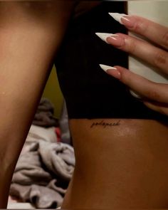 a woman's leg with white nails and a tattoo on her left side that reads, i love you