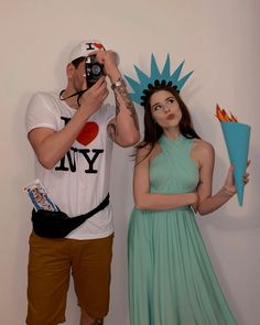 a man taking a photo with a woman dressed as the statue of liberty