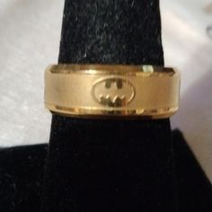 a gold ring with a batman symbol on it