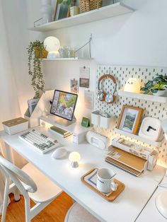 a white desk topped with a computer monitor and keyboard