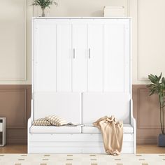 a white bench with pillows and a blanket on it