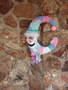 a stuffed toy hanging from the side of a stone wall