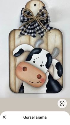 a wooden plaque with a cow on it