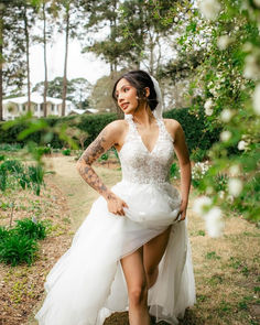 a woman in a white dress is posing for the camera while wearing high heels and tattoos