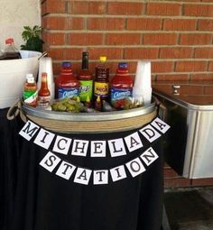 a table topped with lots of condiments next to a brick wall