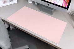 a computer monitor sitting on top of a desk next to a keyboard and mouse pad