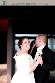 a bride and groom dance together in front of an open door at their wedding reception