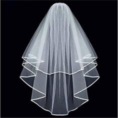 a white veil with ruffles on the bottom is hanging in front of a black background