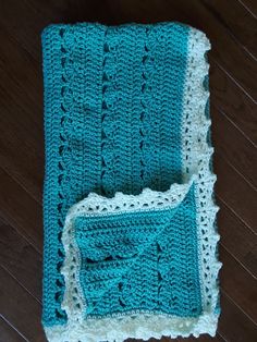 two crocheted afghans sitting on top of a wooden floor