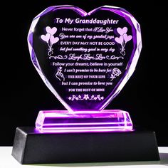 a purple heart shaped glass award on a black stand with the words to my granddaughter