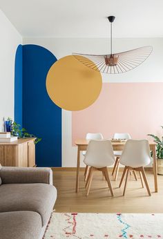 a living room filled with furniture and a painting on the wall above it's dining table