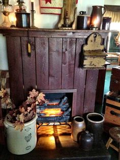 a fire place in a living room filled with pots and pans on top of a table