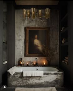 a bathroom with a bathtub and candles in front of a painting on the wall