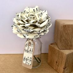 a vase filled with paper flowers next to blocks of wood