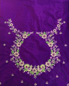 an embroidered purple cloth with white flowers and green leaves on the center, in front of a blue background