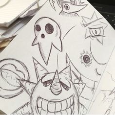 an image of some cartoon characters drawn on paper with pen and marker pens in front of them