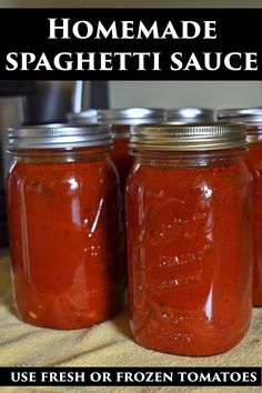 four jars of homemade spaghetti sauce sitting on a table with text overlay that reads, homemade spaghetti sauce use fresh or frozen tomatoes