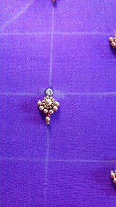 several pieces of jewelry are arranged on a purple surface with white dots and beads in the middle