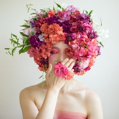 a woman with flowers on her head covering her face