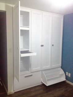 an empty room with white cupboards and shelves