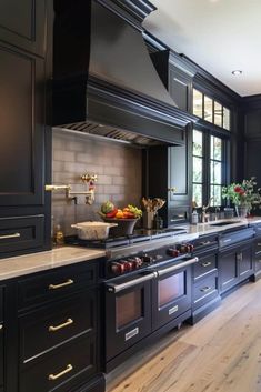 a large kitchen with black cabinets and stainless steel stove top oven, dishwasher, and sink