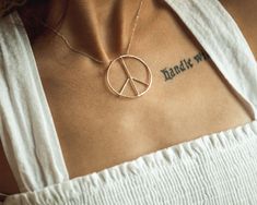 This peace sign necklace carries a powerful message and delivers it in a chic package. An organic circular peace sign pendant sits centered on a delicate chain. This powerfully serene piece illuminates the heart space with radiant fine metal. A light hammered texture gives off a soft glimmer. Its size and sparkle are bold, yet the open wire construction is lightweight and comfortable to wear. Every aspect of this tranquil treasure is intentionally handcrafted. The 1.1mm barely there chain is exp Symbolic Peace Sign Jewelry For Gift, Spiritual Peace Sign Necklace As A Gift, Peace Necklace, Peace Sign Necklace, Sign Necklace, Delicate Chain, Wide Band Rings, Wide Bands, Peace Sign