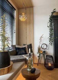 a living room filled with furniture next to a window covered in wooden slatted blinds