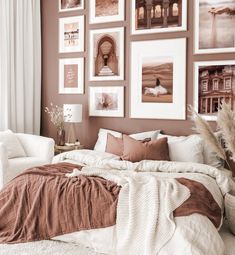 a bed sitting in a bedroom next to a white couch and pictures on the wall