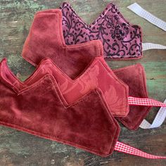 three red and pink bras sitting on top of a wooden table