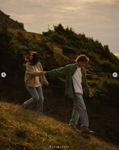 two people walking up a hill holding hands