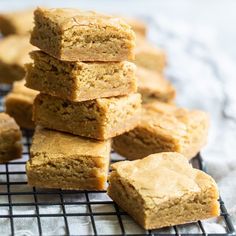 a pile of peanut butter bars sitting on top of a cooling rack next to some cookies