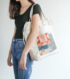 a woman carrying a tote bag in her hands