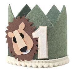 a green felt crown with a lion face on it's front and number one on the side