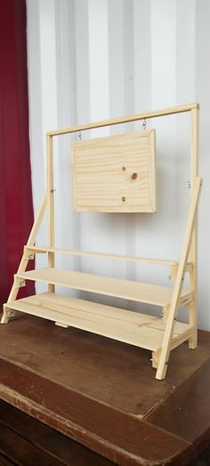 a wooden bench sitting on top of a table next to a red door and striped wall