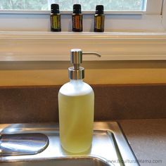 a soap dispenser sitting on top of a sink next to a window