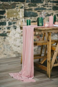 the table is set with pink linen and candles