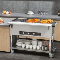 a kitchen with an oven, counter top and dishes on the cart in front of it